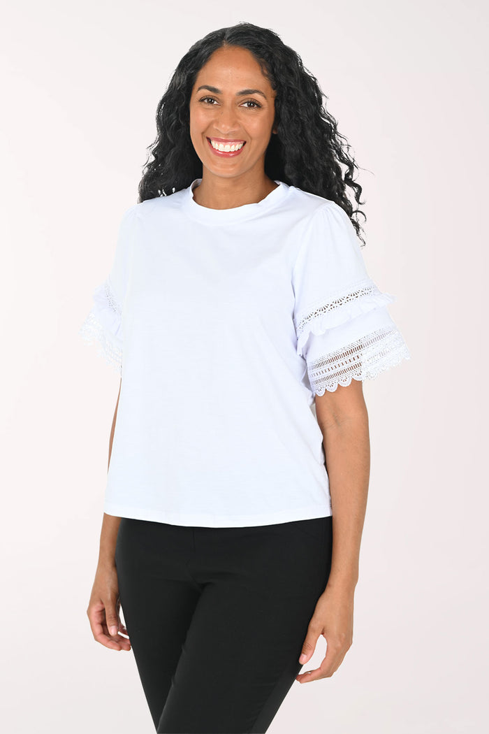 Woman wearing a white top with lace sleeves on a white background