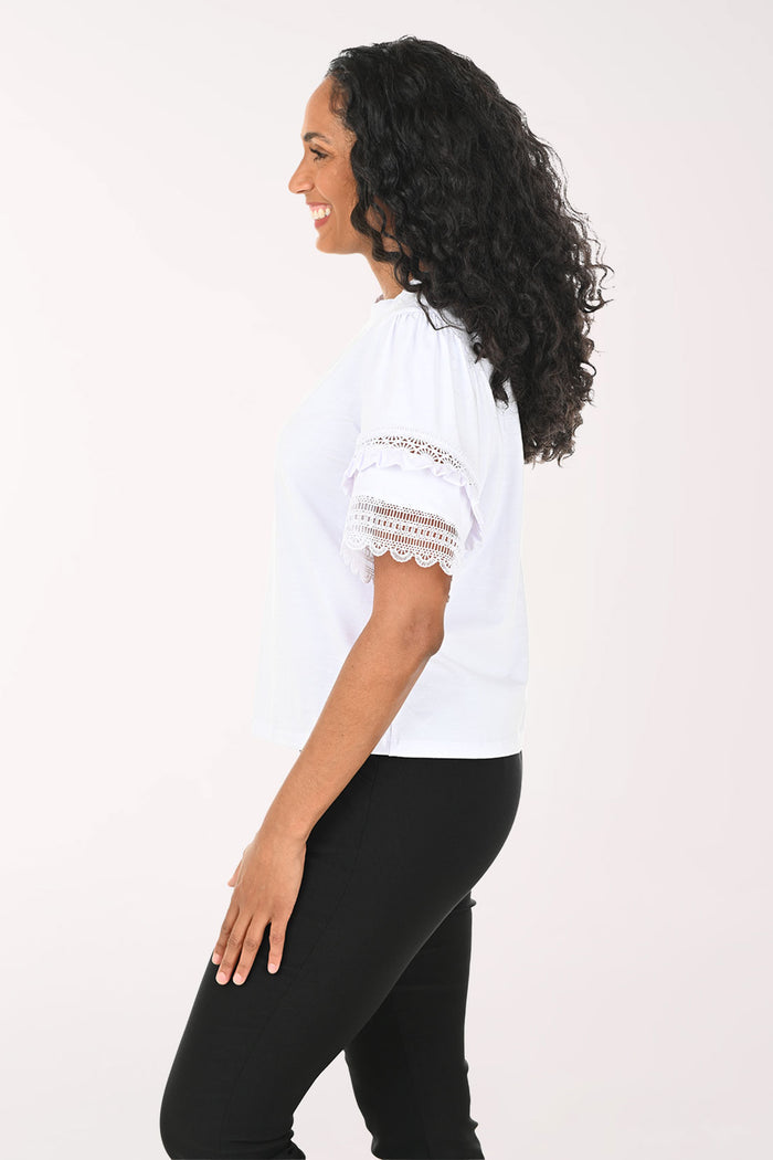 Woman wearing a white top with lace sleeves on a white background