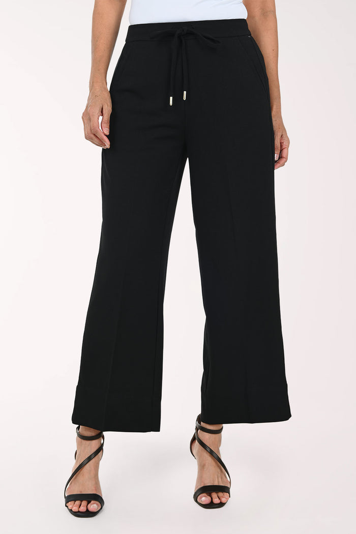 Black wide-leg cropped pants with a drawstring waist, shown on a model wearing black strappy heels against a plain light background.