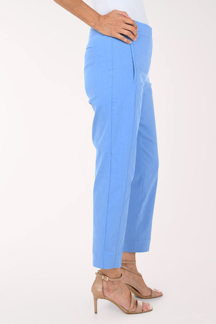 A model wearing light blue cropped trousers with side pockets, paired with beige strappy high-heeled sandals against a plain white studio background.