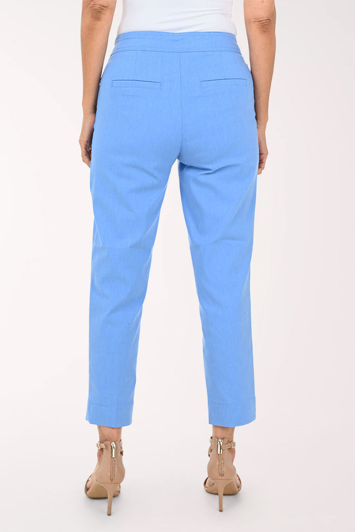 A model wearing light blue cropped trousers with side pockets, paired with beige strappy high-heeled sandals against a plain white studio background.