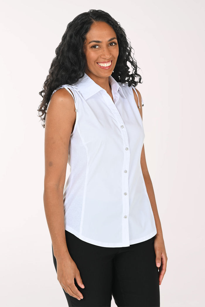 Woman wearing a sleeveless white blouse against a plain background