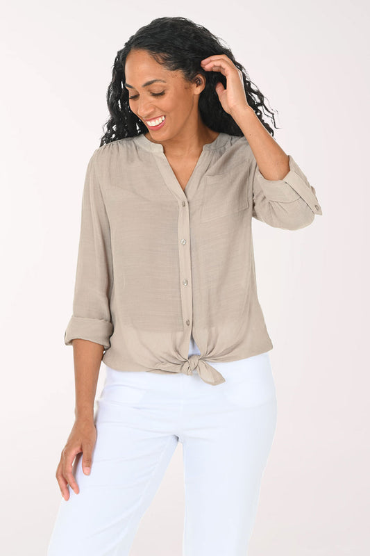 Woman wearing a beige button-up shirt with a white background
