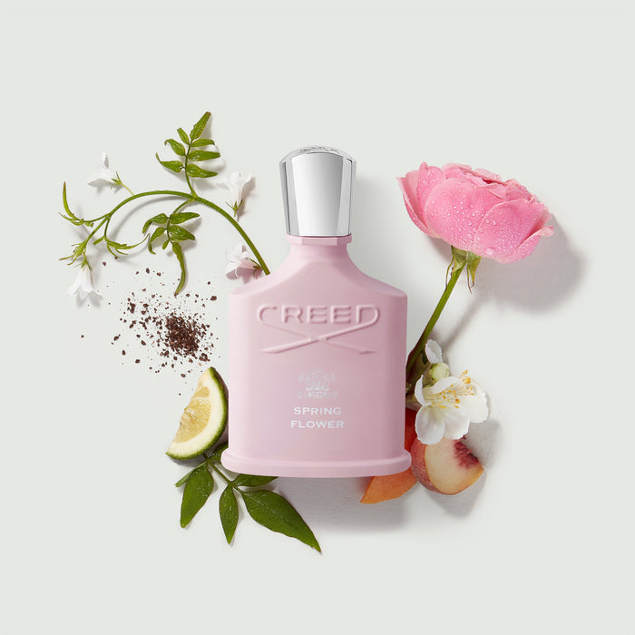 Creed Spring Flower pink perfume bottle surrounded by rose, jasmine, peach and lime fragrance notes - Ingredient Flatlay | Creed Fragrances