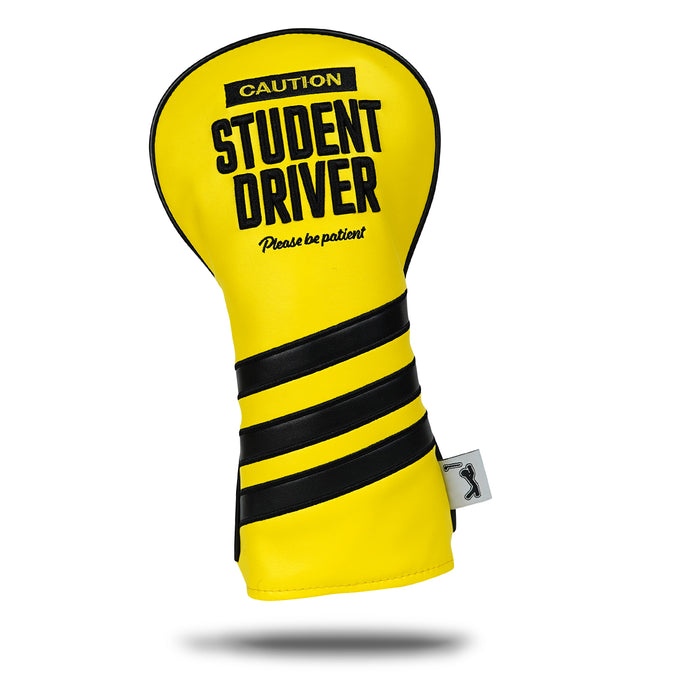 The Student Driver - Driver Headcover is bright yellow PU leather with bold black "CAUTION STUDENT DRIVER Please be patient" text, three black diagonal stripes at the bottom, and a small white side tag.