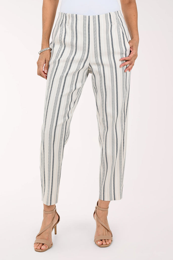 A model wearing cropped trousers with vertical gray and black stripes on an off-white background, paired with beige strappy high-heeled sandals.