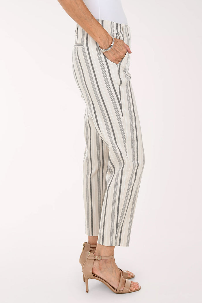A model wearing cropped trousers with vertical gray and black stripes on an off-white background, paired with beige strappy high-heeled sandals.
