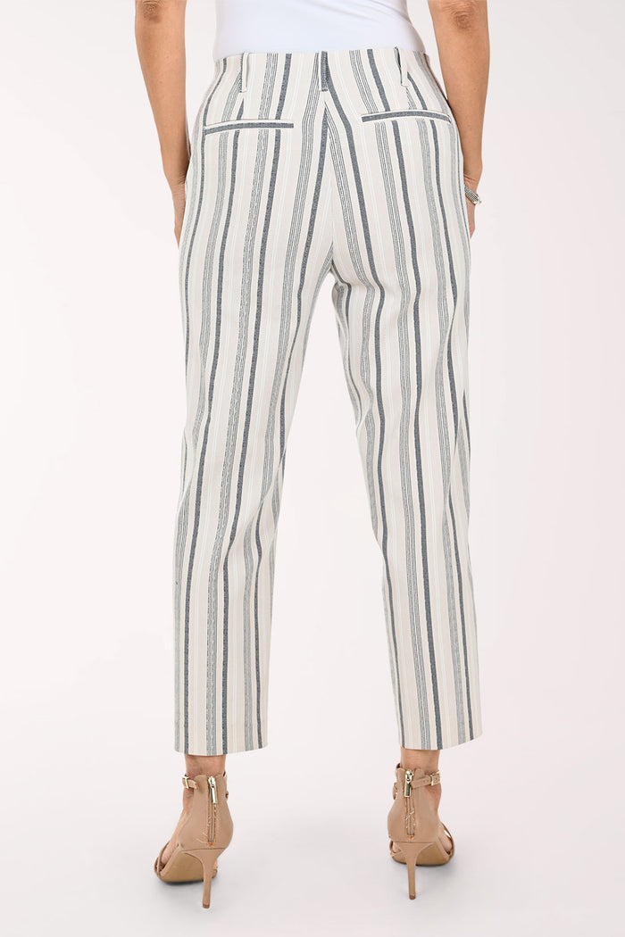 A model wearing cropped trousers with vertical gray and black stripes on an off-white background, paired with beige strappy high-heeled sandals.