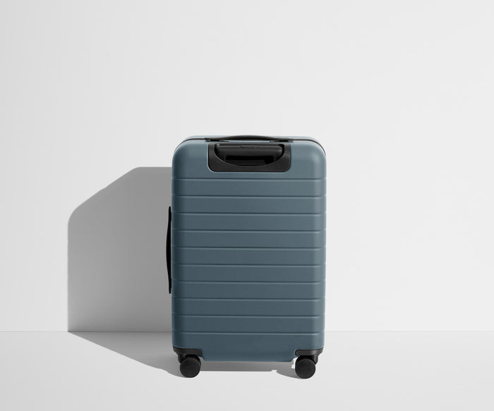 Back product view of The Bigger Carry-On suitcase in Coast Blue