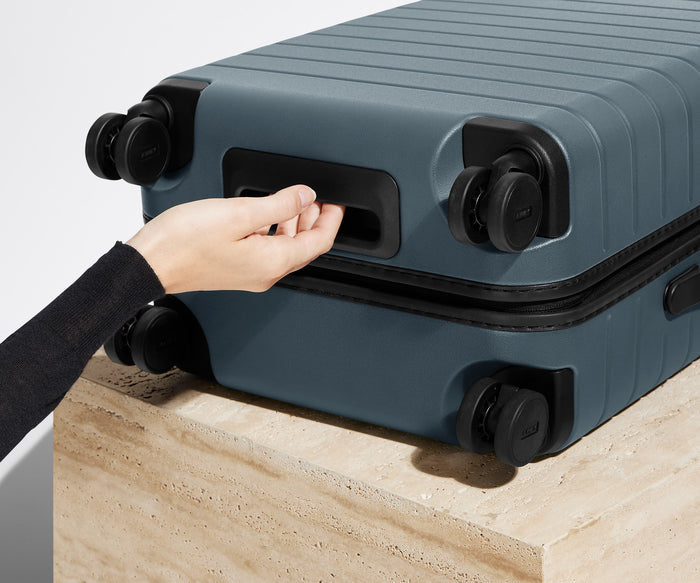 The Carry-On suitcase in Coast Blue shown from below highlighting the underside grab handle
// 
Underside grab handle that makes it easier to lift and carry your suitcase.