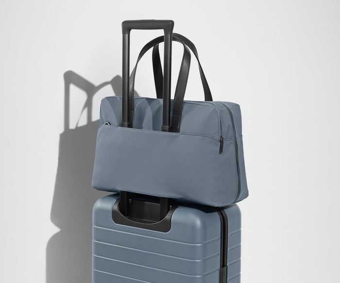 The Everywhere Bag secured to an Away suitcase by its trolley sleeve
// Our Everywhere Bags are designed with a trolley sleeve that slides onto your suitcase to keep it in place while you’re on the move. Paired with The Bigger Carry-On.