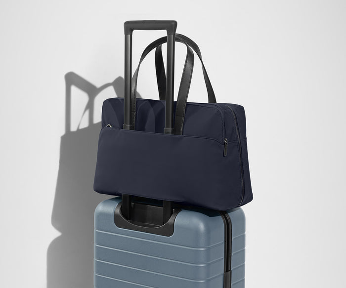 The Everywhere Bag secured to an Away suitcase by its trolley sleeve
// Our Everywhere Bags are designed with a trolley sleeve that slides onto your suitcase to keep it in place while you’re on the move. Paired with The Bigger Carry-On.