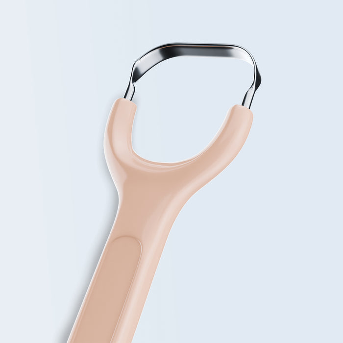 Stainless steel tongue scraper with peach handle on white background