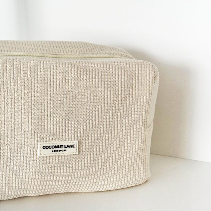 Cream Coconut Lane waffle makeup bag with a visible zipper, displayed on a plain white background.