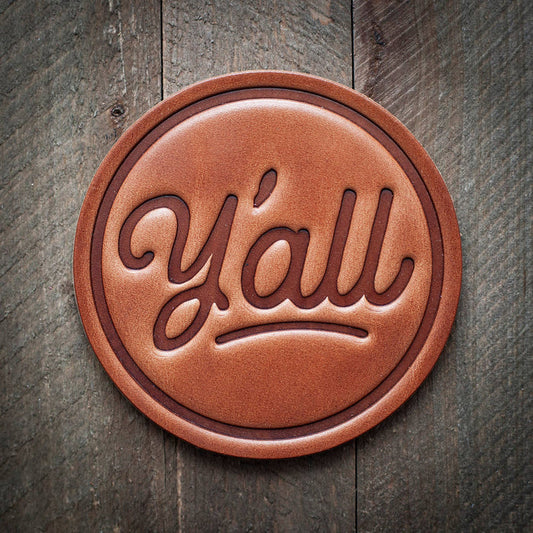 Leather coaster with the word y'all.